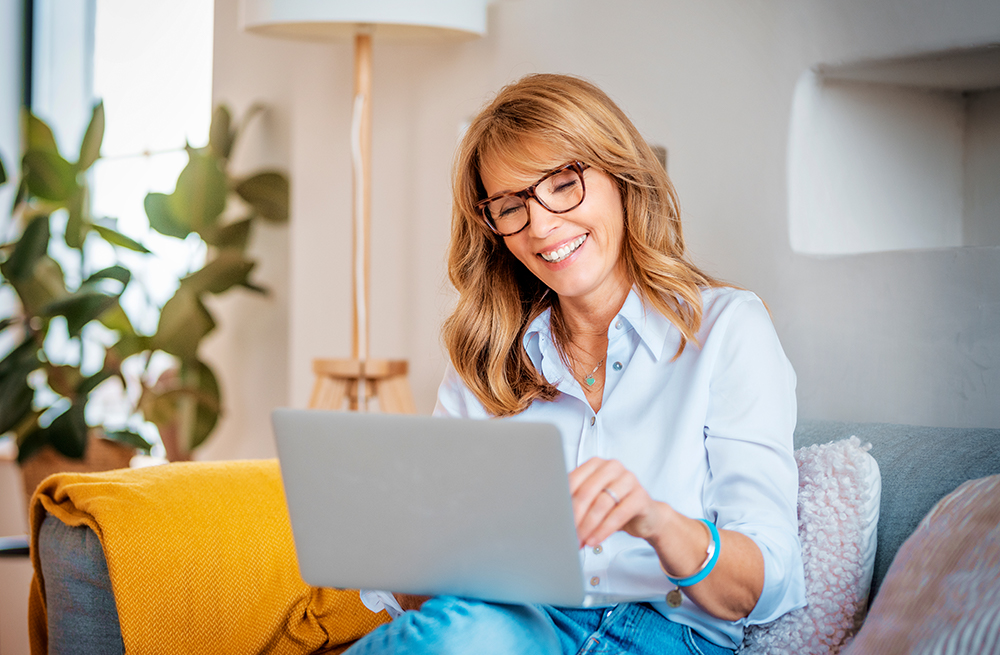 Vrouw zoekt op een laptop of de verzekering continue glucosemeters dekt.